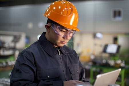 年轻工人在工厂操作数字化设备